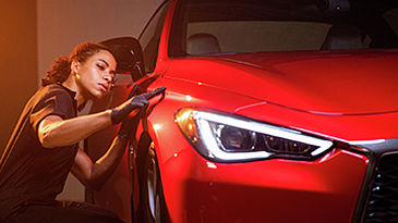 Technician inspecting red car