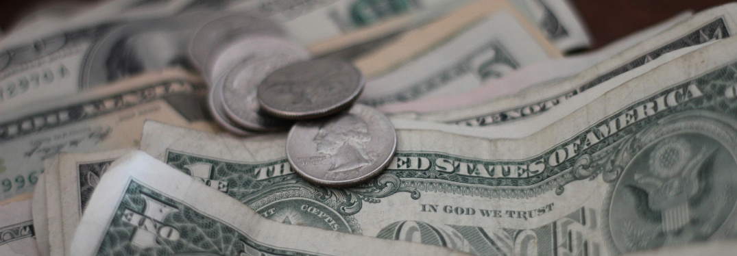 Pile of dollar bills and coins