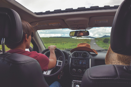 Man driving with hat sitting on dashboard