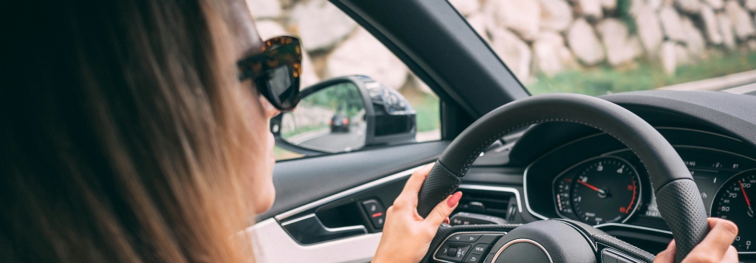 Woman wearing sunglasses driving car